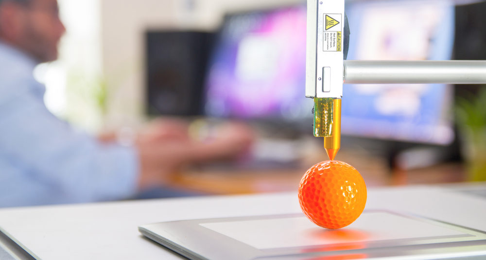 3D printer printing orange ball.